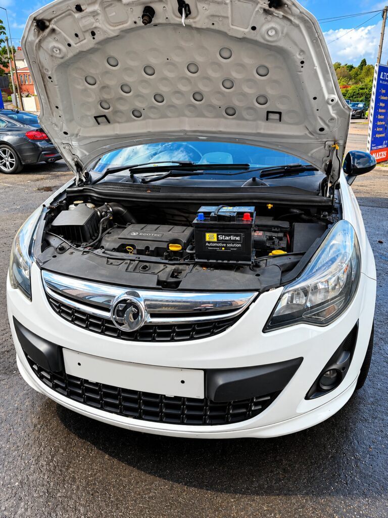 White Vauxhall Corsa with the bonnet open and a new A1 Starline battery ready to fit