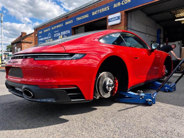 Red Porsche with its wheels removed during tyre fitting at LTC Tyres and Exhausts Stourbridge