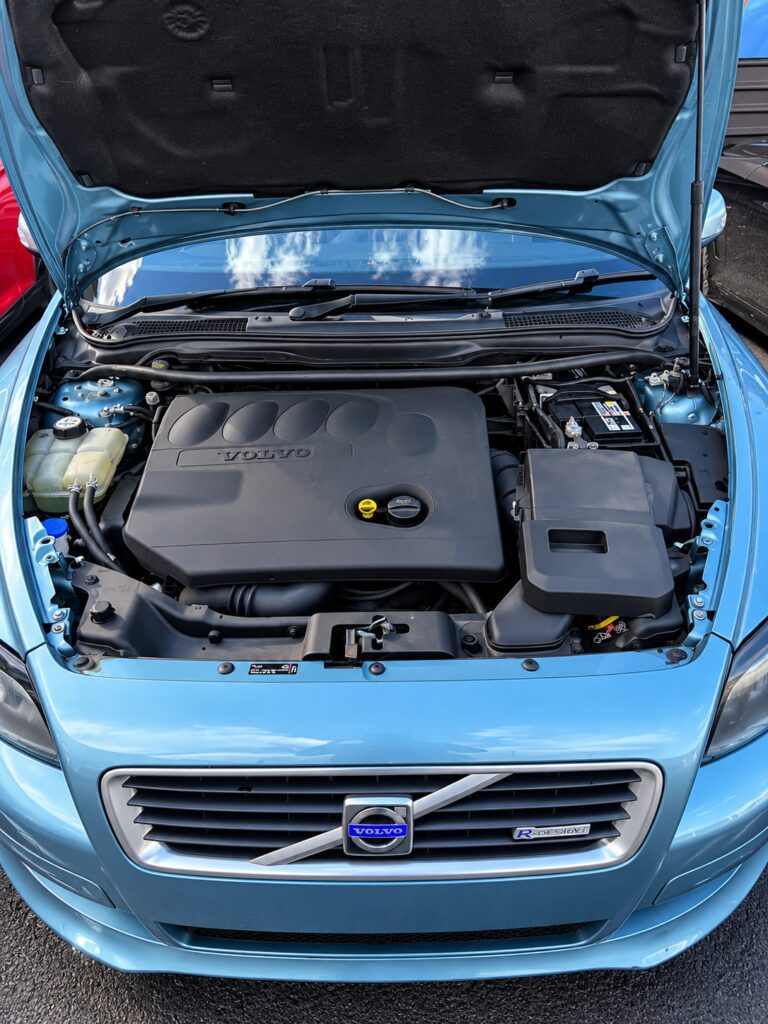 Blue Volvo C30 SE Sport with the bonnet open and a new battery fitted